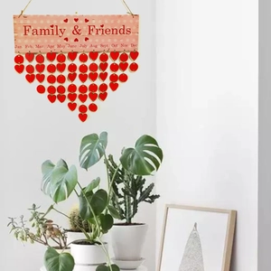Detail of wooden family birthday tracker with red heart tags on a white wall
