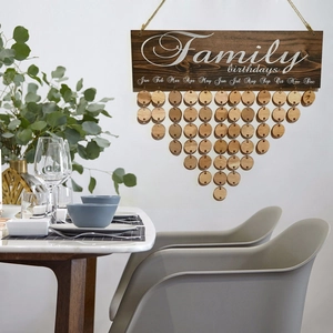 Wooden family birthday calendar plaque with hanging tags on a white wall decor background