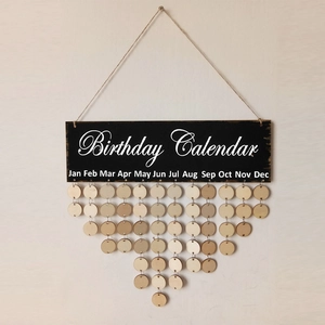 Close-up of a wooden birthday calendar board with hanging round tags on a light wall