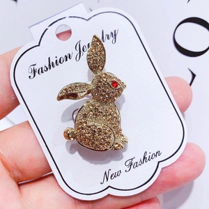 Close-up of golden rabbit brooch with sparkling brown rhinestones and red eye detail