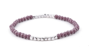 Macro shot of purple faceted beads and silver cube charms on an elastic stretch bracelet