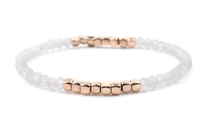 Detail of Miyuki stretch bracelet with white faceted beads and rose gold cubic metal spacers