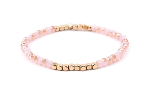 Close-up of pink crystal beads and golden square metal beads on elastic bracelet