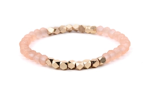 Detailed view of pink frosted beads and faceted gold metal beads on an elastic bracelet
