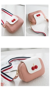 Close-up of pink and white cherry shoulder bag with striped webbing strap detail