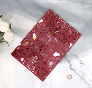 Macro detail of red laser-cut floral wedding invitation with delicate hollow texture
