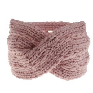 Detail of pink cable knit headband showing thick yarn texture and cross knot design