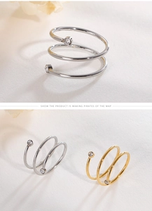 Detail of layered spiral open rings in gold and silver finish with zircon accents