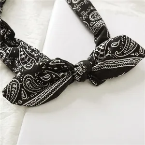 Black paisley cotton headband with rabbit ears bow tie on elegant white card display