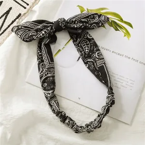 Detail of paisley print knotted headband with elastic band on a lifestyle background