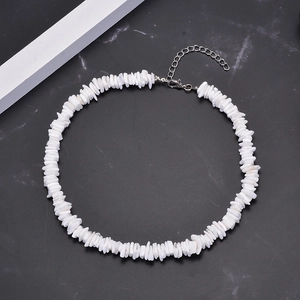White irregular shell chip necklace set with adjustable metal chain on marble background
