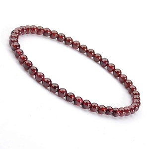 Macro shot of 4mm garnet beads bracelet with polished deep red natural stone texture