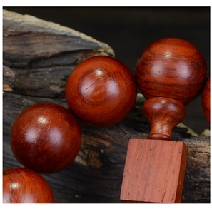 Macro shot showing the natural wood grain and oil texture of the red sandalwood beads