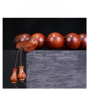 Macro detail of Rosewood prayer beads with square wood block and small gourd pendants