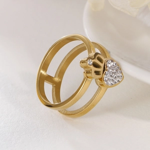 Golden double-layered ring featuring a crown and heart zircon inlay on a textured background