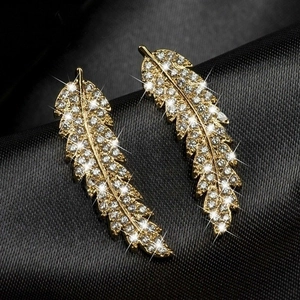 Elegant gold leaf earrings with micro-paved zircons on black silk background