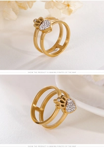 Macro detail of gold double-layer ring featuring a sparkling zircon heart and crown element