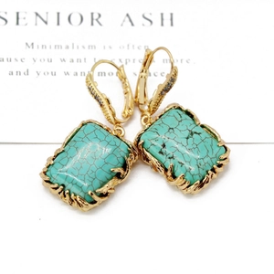 Elegant gold earrings with rectangular turquoise stones and zircon accents on white background