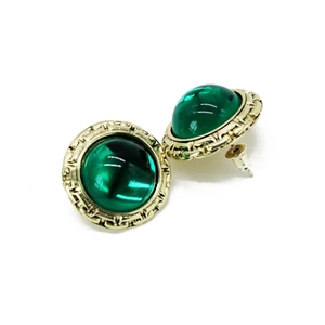 Detail of vintage round earrings with dark green resin stone and gold textured frame