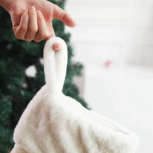 White faux fur Christmas stocking with hanging loop and soft plush texture for holiday decor