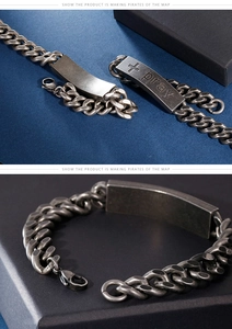 Macro shot of vintage silver cross pray engraving on curved stainless steel link chain