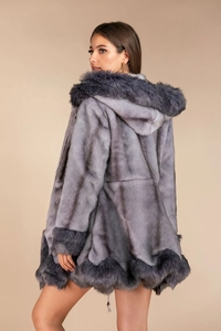 Detail view of the drawstring hem and plush faux fur texture on a grey hooded coat