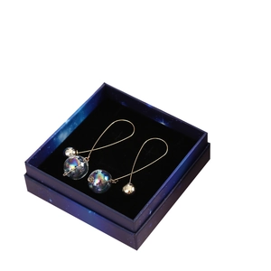 Iridescent glass ball earrings in gold setting presented in starry blue jewelry gift box