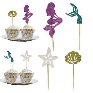 Detail showing glitter mermaid tail cake toppers and shells on bamboo sticks
