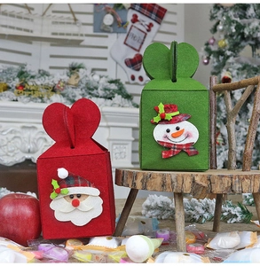 Close-up of red and green felt Christmas gift bags with 3D Santa and Snowman embroidery