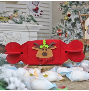 Macro view of red candy-shaped Christmas felt gift bag with 3D cartoon reindeer design