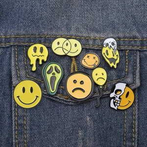 Creative cartoon enamel pins with smiley and skull balloon designs on denim jacket