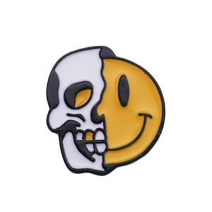 Gros plan détaillé de la broche en émail de haute qualité avec tête de mort et smiley