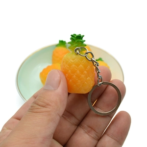 Handheld lifelike orange pineapple keychain with green leaves and silver metal ring