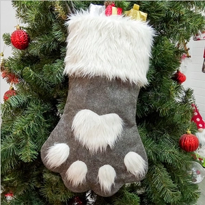 Creative gray and white dog paw Christmas stocking hanging on a festive decorated tree