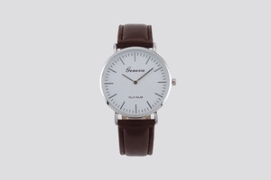 Close-up of minimalist white dial with silver metal case and brown leather strap