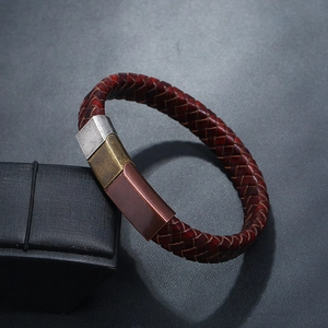Close-up of red-brown braided leather bracelet with tri-color magnetic metal clasp
