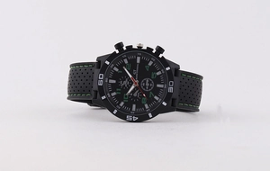 Detail of sport watch with black perforated silicone strap and green stitching accents