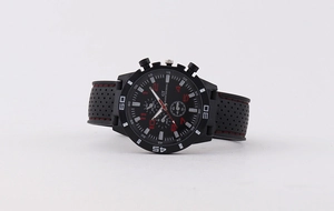 Detail view of sport watch with black rubber strap, red stitching and three subdials