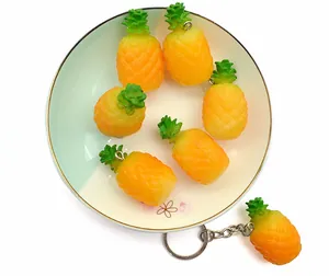 Detailed close-up of realistic PVC pineapple keychains on a decorative plate