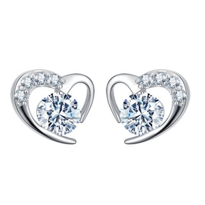 Detailed close-up of heart-shaped silver stud earrings with sparkling cubic zirconia stones