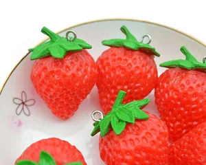 Detailed macro view of realistic red PVC strawberries with green leaves in a white ceramic dish