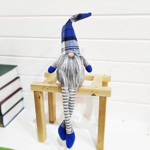 Nordic Christmas gnome plush with blue plaid hat and long legs on a wooden bench