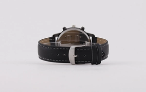 Detailed view of black leather watch strap with white contrast stitching and silver buckle