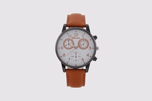 Detail of white dial with rose gold numerals and brown leather strap on quartz watch