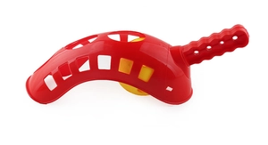 Detail of red curved plastic launcher and yellow hollow ball for outdoor catch games