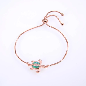 Detail of rose gold turtle bracelet with green opal inlay and adjustable slider chain
