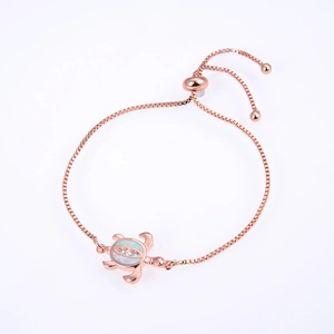 Rose gold turtle bracelet with white opal inlay and zircon stones on white background