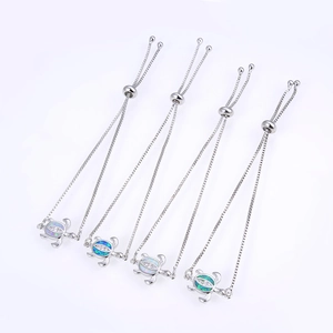Detail of four silver turtle bracelets with colorful opal stones and zircon settings