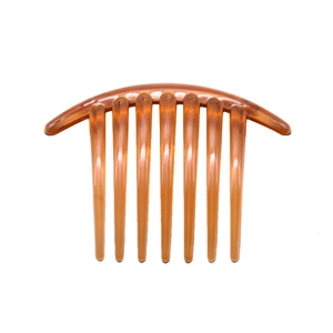 Close-up of smooth amber brown plastic hair side comb with nine teeth on white background