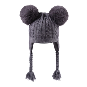 Close-up of purple knit hat for kids with dual faux fur pom-poms and braided tassels
